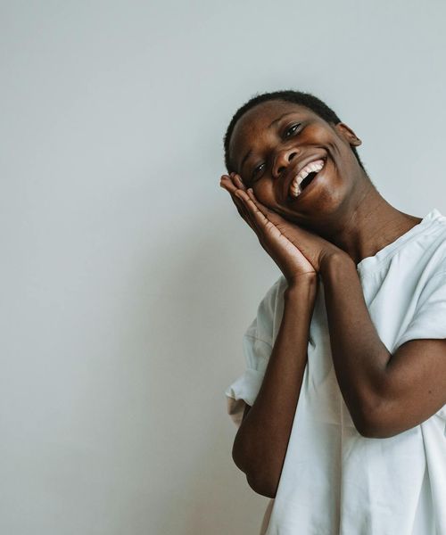 Portrait of a smiling woman, the yoga instructor, in a bright, welcoming space.