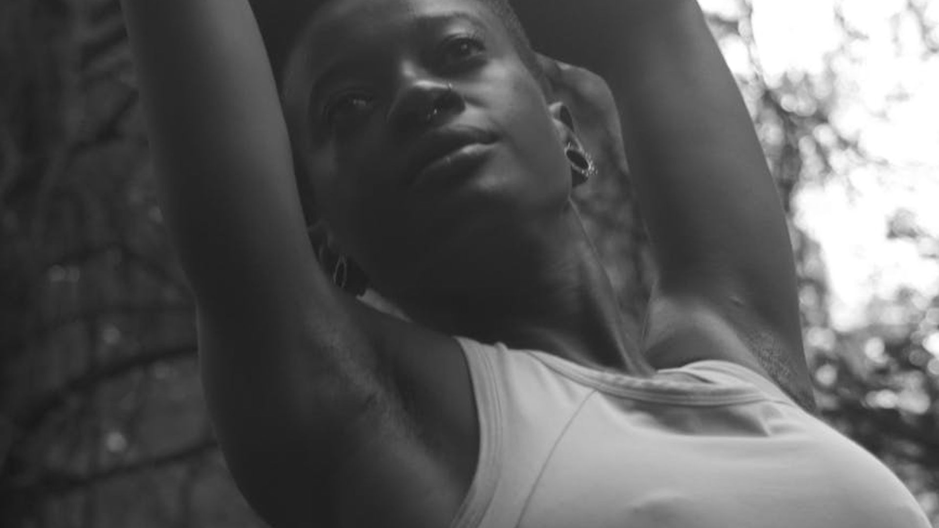 Silhouette of a woman in a graceful yoga pose against a dark, minimalist background.
